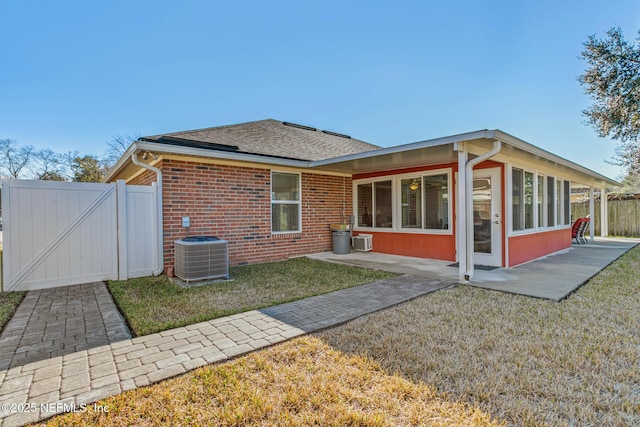 back of property featuring central AC unit, a yard, and a patio