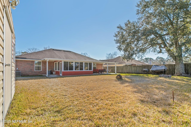 rear view of property with cooling unit and a yard