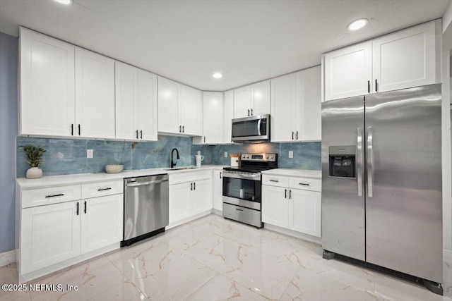 kitchen featuring tasteful backsplash, sink, stainless steel appliances, and white cabinets