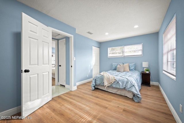 bedroom featuring a textured ceiling and light wood-type flooring