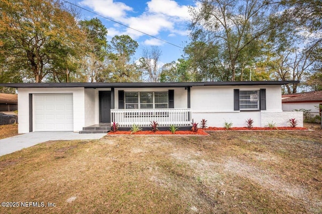 ranch-style home featuring a garage, covered porch, and a front lawn