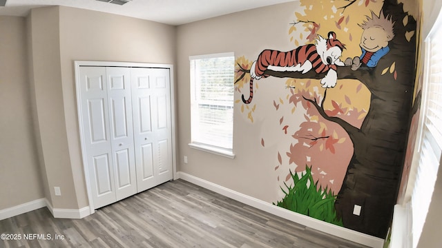 unfurnished bedroom featuring wood-type flooring and a closet