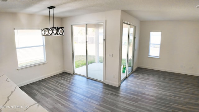 doorway to outside with dark hardwood / wood-style flooring, a wealth of natural light, and a textured ceiling