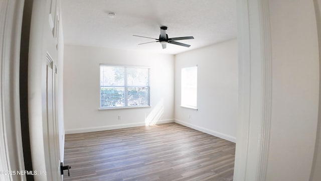 empty room with ceiling fan, a textured ceiling, and light wood-type flooring