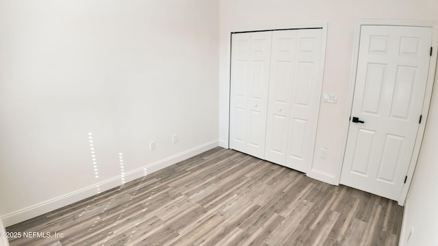 unfurnished bedroom featuring hardwood / wood-style flooring and a closet