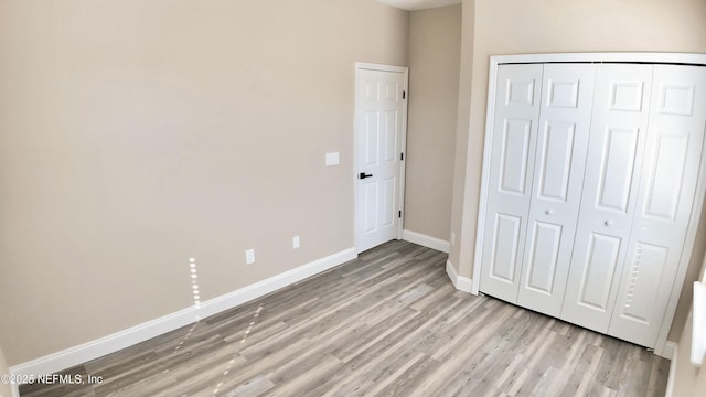 unfurnished bedroom featuring a closet and light wood-type flooring