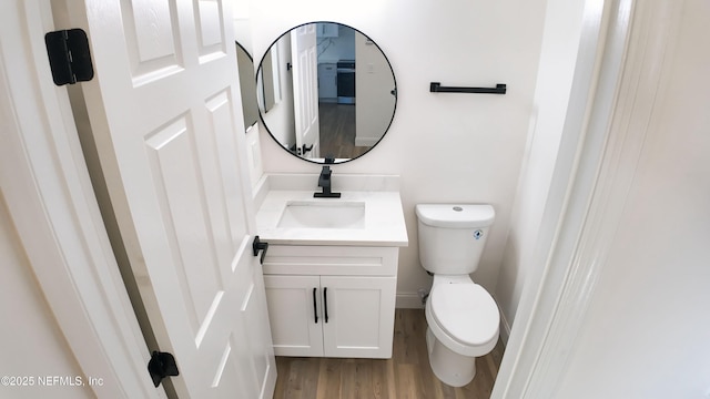 bathroom with vanity, wood-type flooring, and toilet