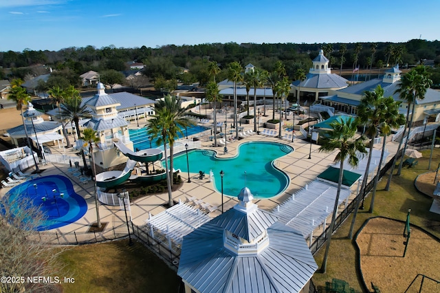 view of swimming pool featuring a water slide and a patio area