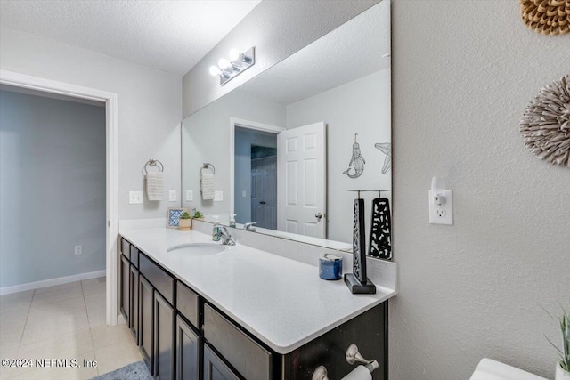 bathroom featuring tile patterned flooring, vanity, and a textured ceiling