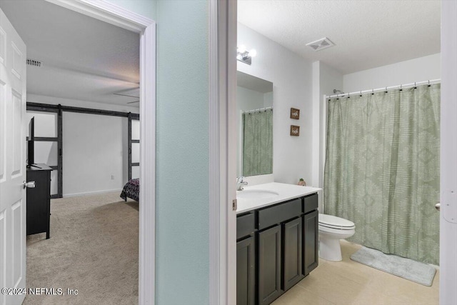 bathroom featuring vanity, toilet, and a textured ceiling