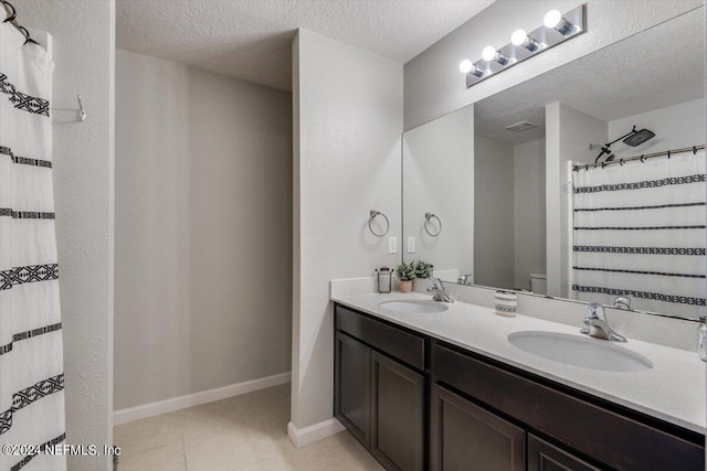 bathroom featuring tile patterned floors, vanity, and a textured ceiling