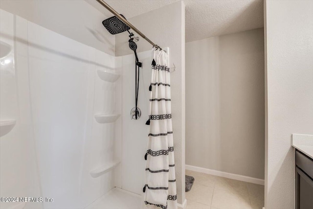 bathroom with tile patterned floors, a shower with shower curtain, a textured ceiling, and vanity