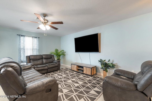 living room featuring ceiling fan, carpet flooring, and a textured ceiling