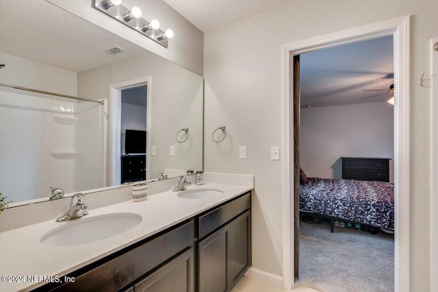 bathroom featuring vanity, ceiling fan, and a textured ceiling