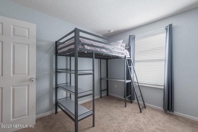 bedroom with multiple windows, light colored carpet, and a textured ceiling