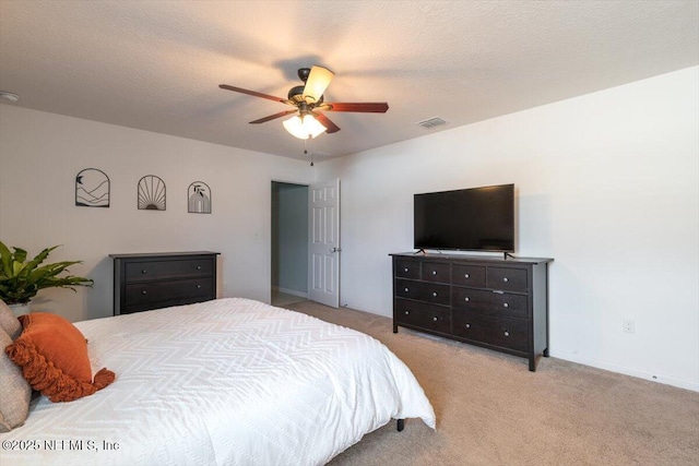 carpeted bedroom with ceiling fan and a textured ceiling