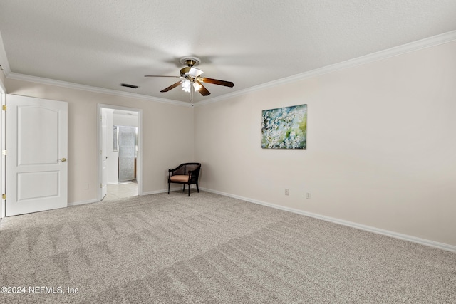 carpeted spare room with ceiling fan, ornamental molding, and a textured ceiling