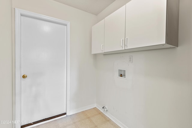 clothes washing area with cabinets and hookup for a washing machine