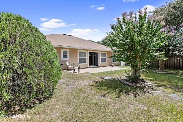 back of house featuring a lawn and a patio