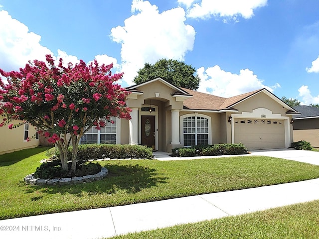 view of front of property featuring a garage and a front yard