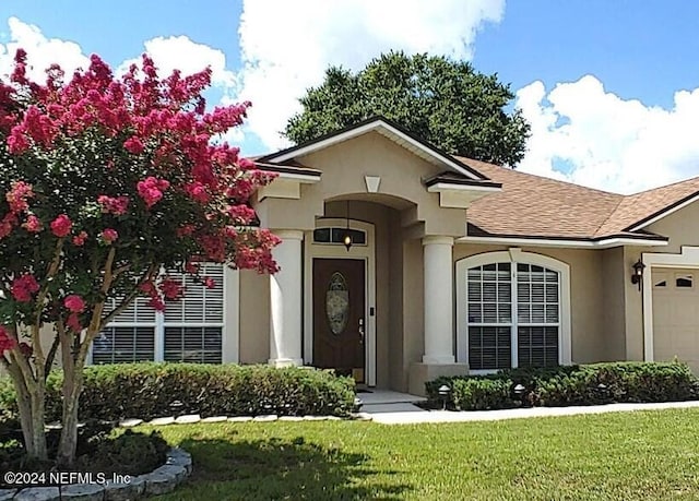 view of front of home featuring a garage and a front lawn