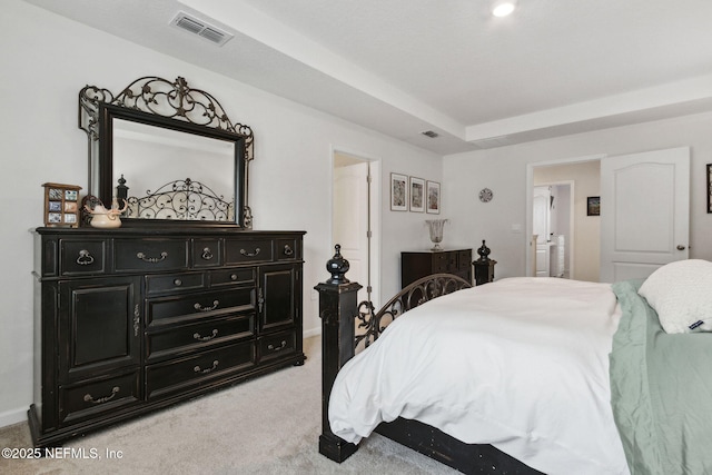 carpeted bedroom with a tray ceiling