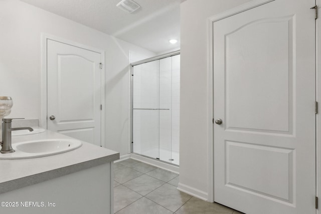 bathroom with vanity, tile patterned flooring, and a shower with door