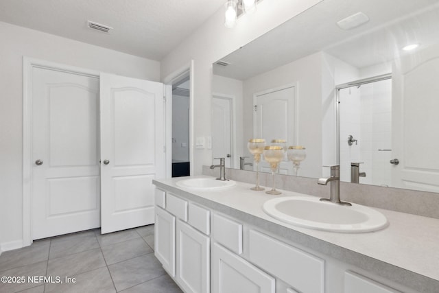 bathroom featuring vanity, tile patterned floors, and walk in shower