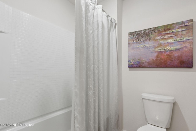 bathroom featuring shower / bath combination with curtain and toilet