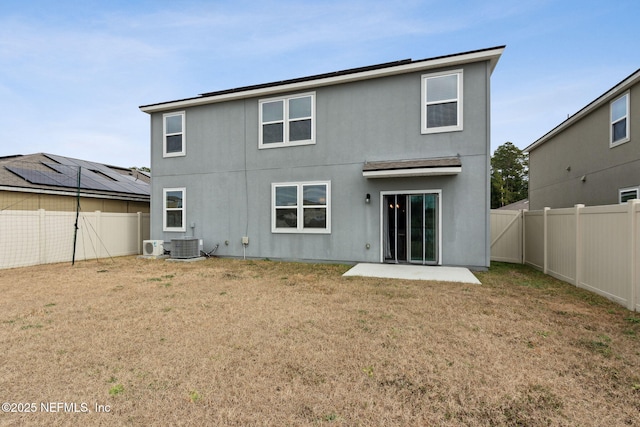 back of house featuring central AC unit, a lawn, and a patio