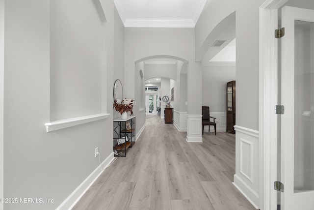 hall featuring ornamental molding and light hardwood / wood-style floors