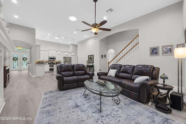 living room featuring french doors, ceiling fan, and light wood-type flooring