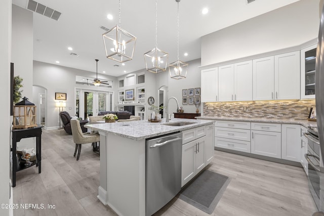 kitchen with white cabinetry, appliances with stainless steel finishes, sink, and a center island with sink