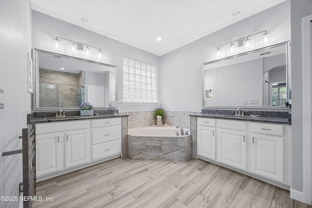 bathroom featuring independent shower and bath, vanity, and hardwood / wood-style floors