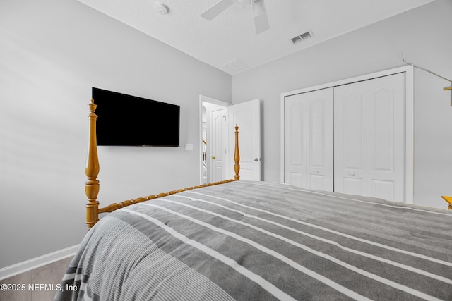 bedroom featuring hardwood / wood-style flooring, ceiling fan, a closet, and a textured ceiling