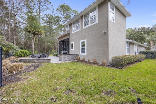 back of house with a lawn, a sunroom, and a patio