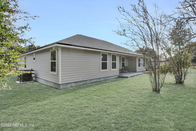 rear view of property with central AC unit, a lawn, and a patio area