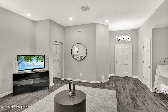 foyer entrance featuring dark wood-type flooring and a chandelier