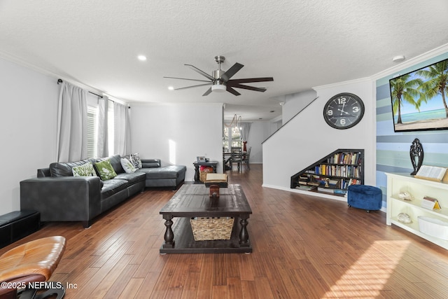 living room with wood-type flooring, crown molding, and a textured ceiling