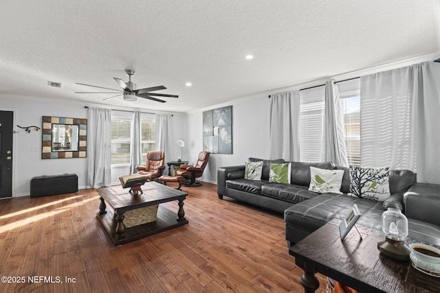 living room with crown molding, ceiling fan, hardwood / wood-style flooring, and a textured ceiling