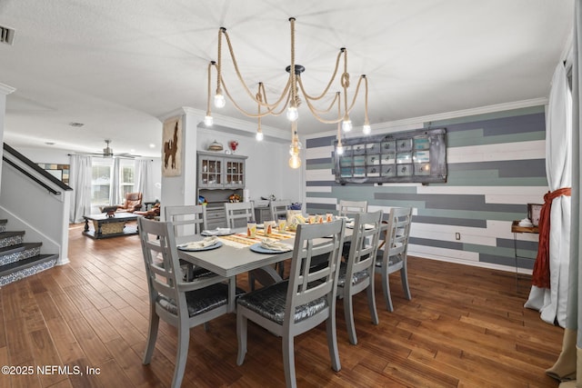 dining room featuring crown molding, ceiling fan with notable chandelier, and dark hardwood / wood-style flooring