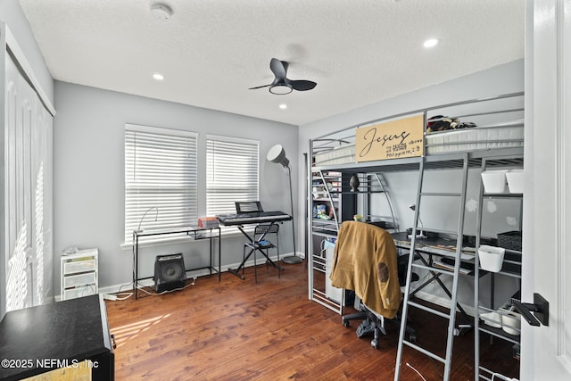 bedroom featuring ceiling fan, a textured ceiling, dark hardwood / wood-style flooring, and a closet