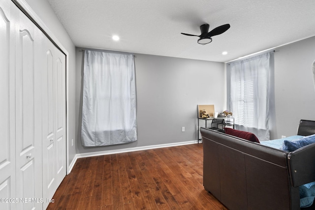 living room with dark hardwood / wood-style floors, a textured ceiling, and ceiling fan