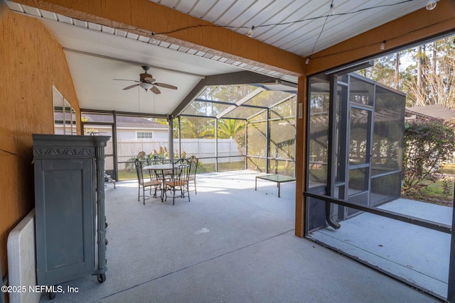 unfurnished sunroom featuring lofted ceiling, a wealth of natural light, and ceiling fan