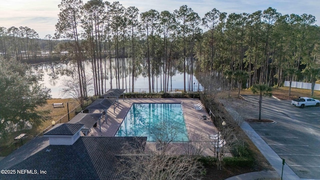 view of pool featuring a water view and a patio