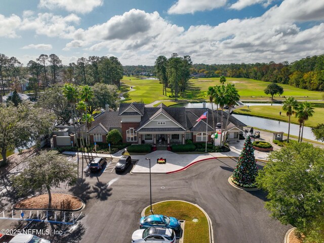 drone / aerial view with a water view and golf course view