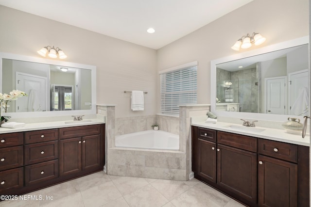 bathroom featuring a shower stall, a bath, and vanity