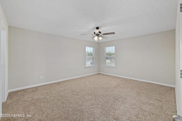 empty room featuring carpet, baseboards, ceiling fan, and a textured ceiling