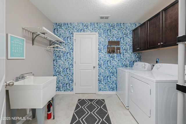 laundry area with washer and dryer, sink, cabinets, and a textured ceiling