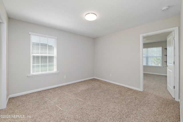 empty room featuring carpet floors and baseboards